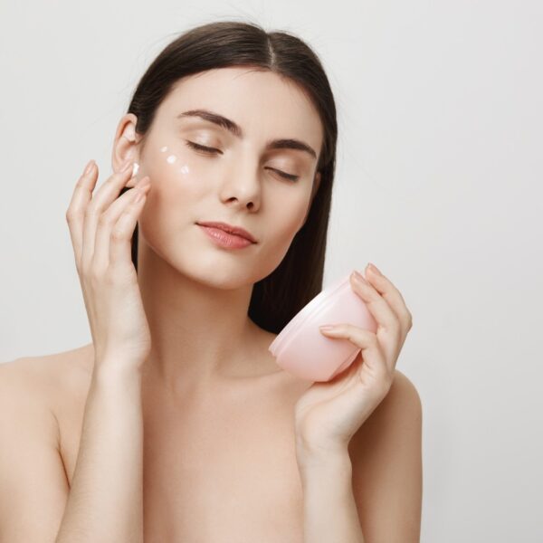 Attractive woman apply facial cream anti aging product 2000px 600x600