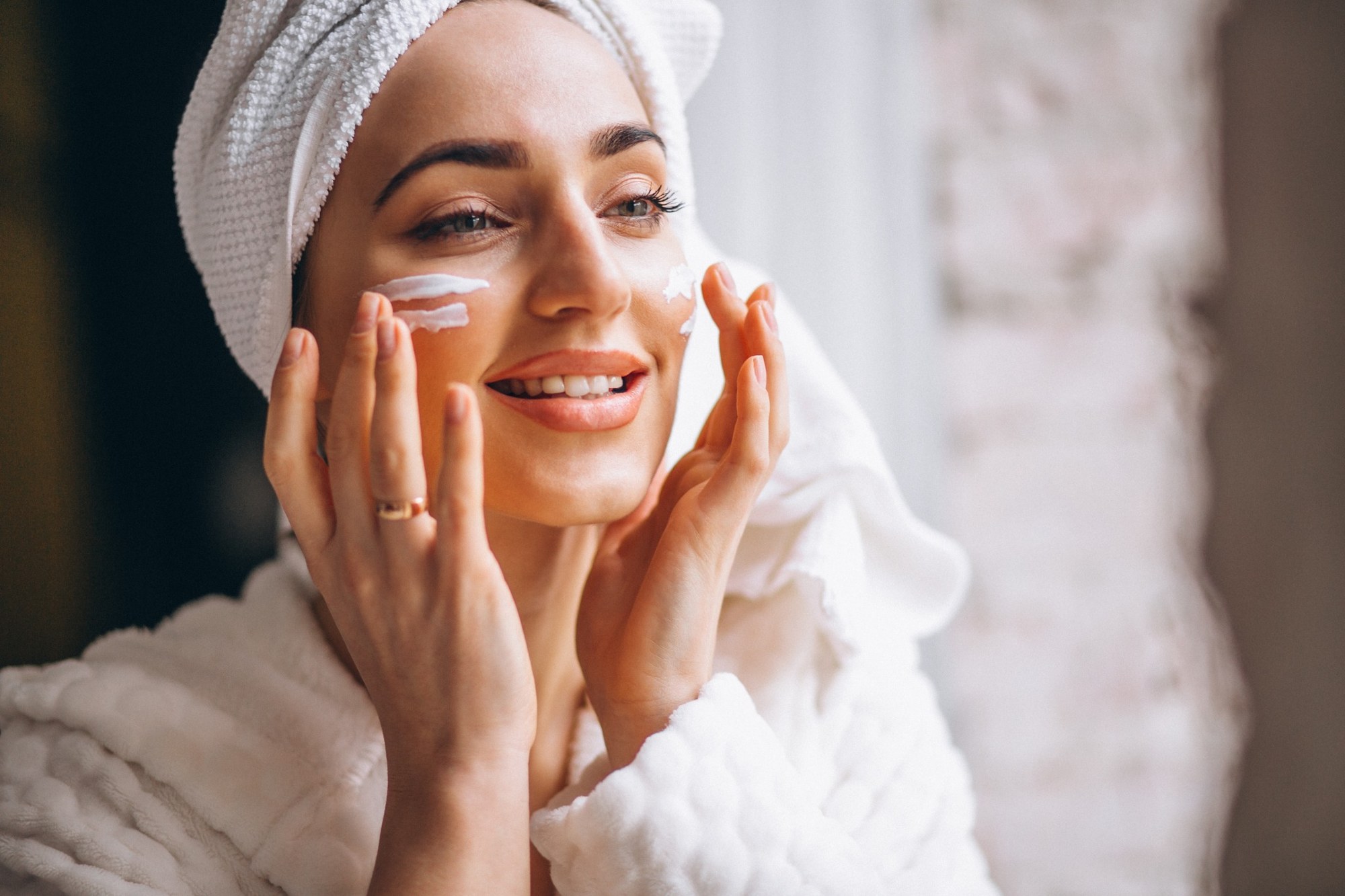 Woman applying face cream 2000px